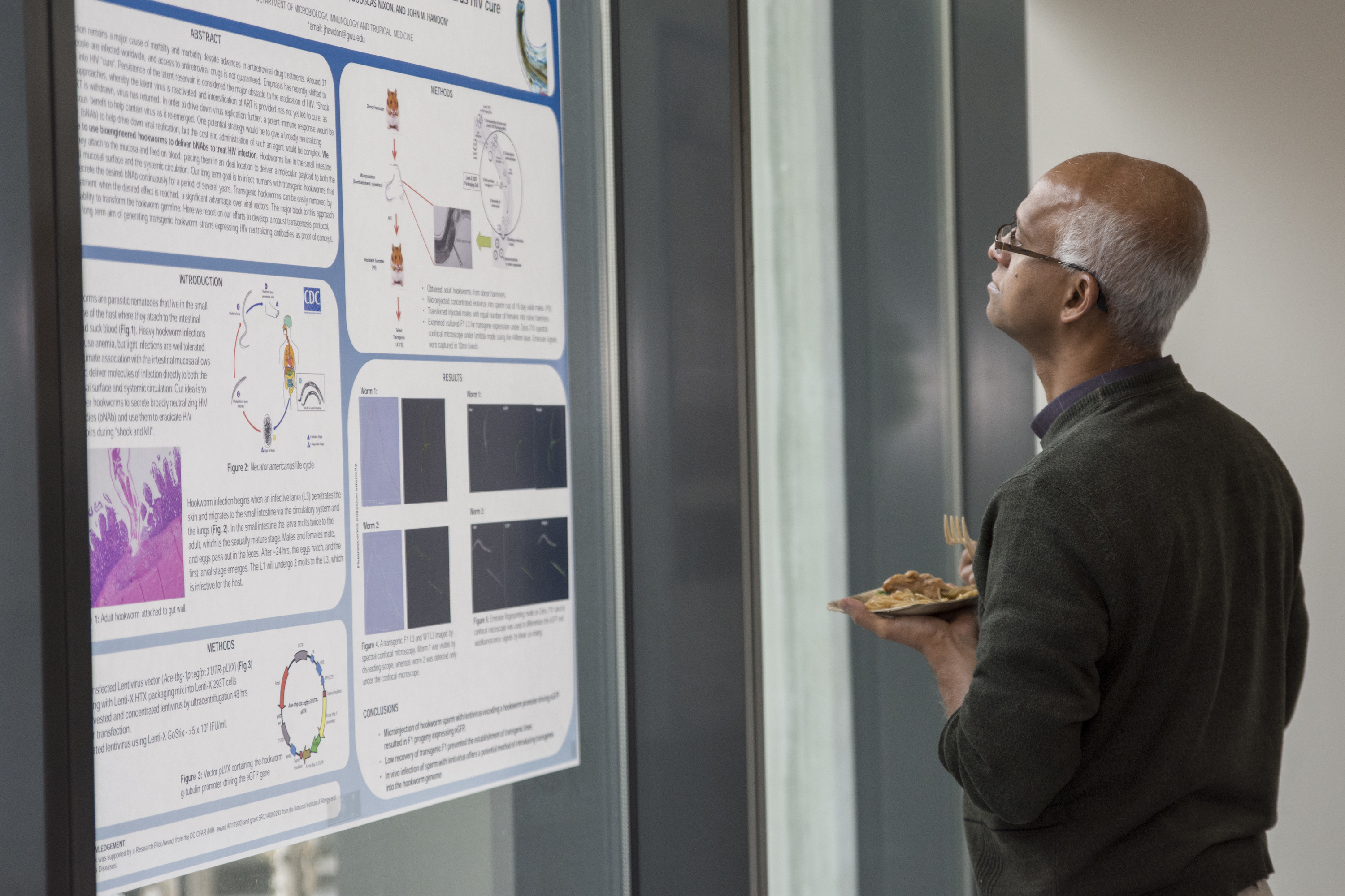 The guest observes a poster session and takes notes